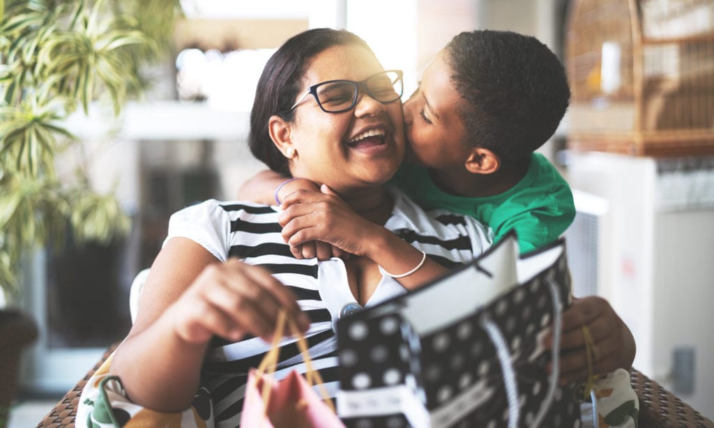 son kissing mom with gifts